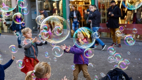 Kinder spielen mit Seifenblasen