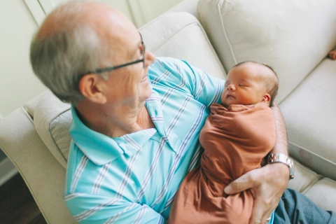 Alter Mann mit Baby auf dem Arm